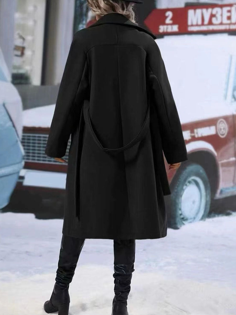 Woman in long belted double-breasted coat