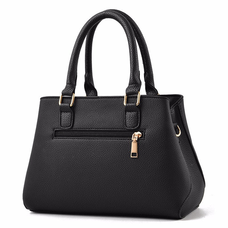 Embossed handbag with pompom charm