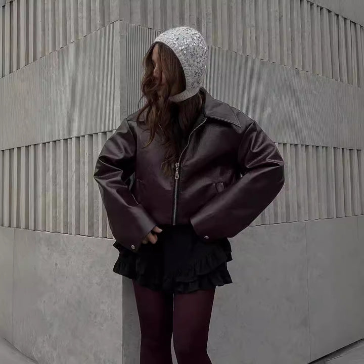 Woman in a cropped burgundy leather jacket