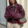 Woman in a cropped burgundy leather jacket